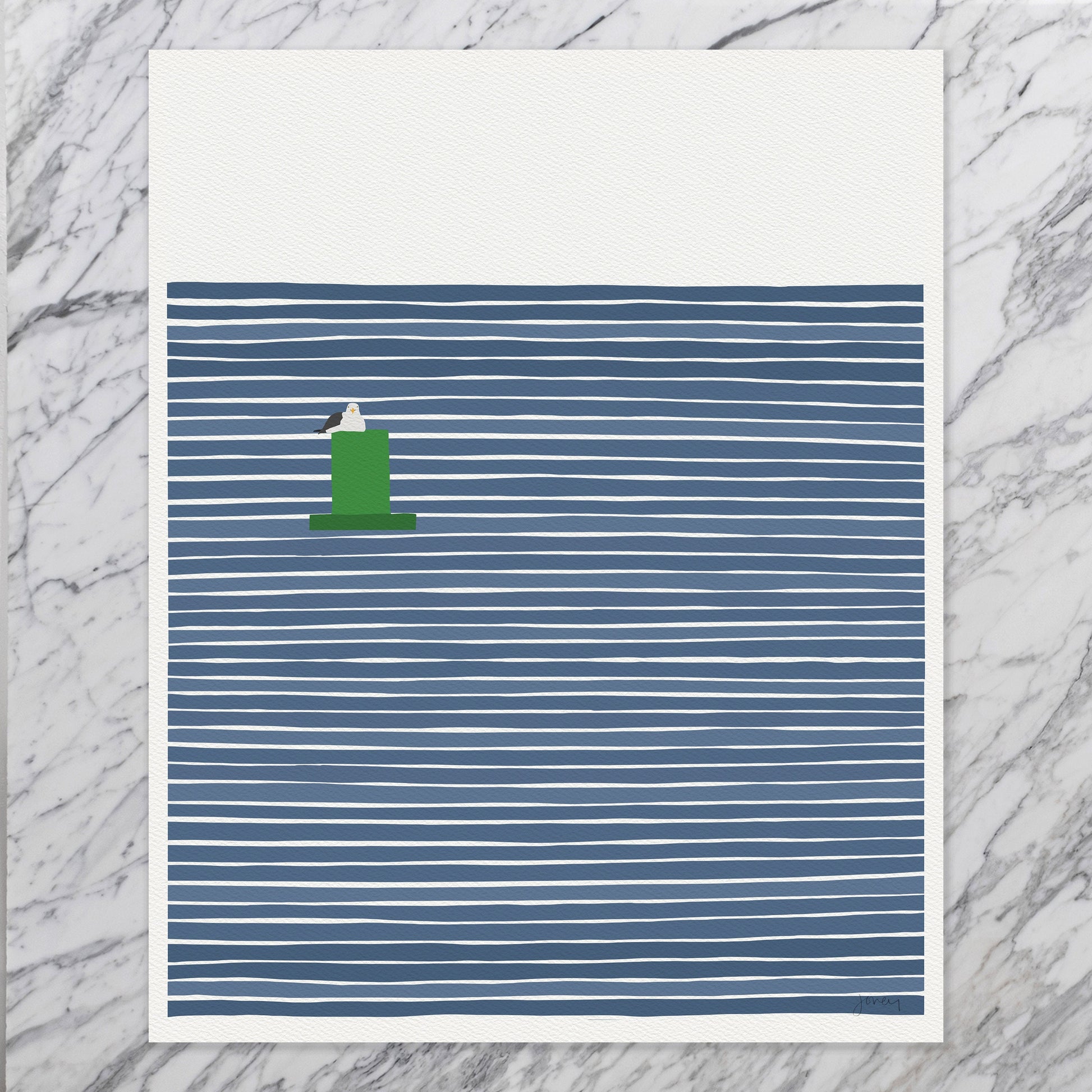 an unframed art print sitting on a marble tabletop. the print depicts a seagull sitting on a green channel marker buoy against a background of navy blue striped water. it is signed by artist Jorey Hurley and is on thick luxe paper.